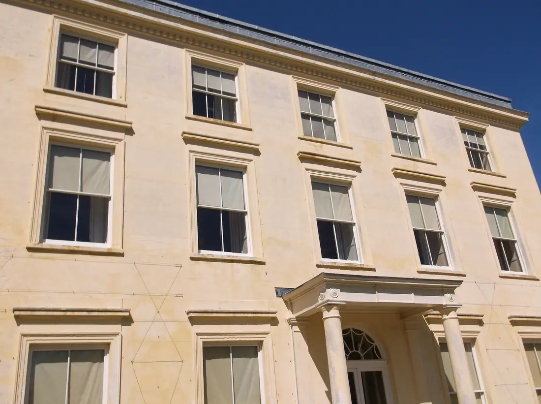 The white Georgian front of Greenway House above the River Dart in Devon.