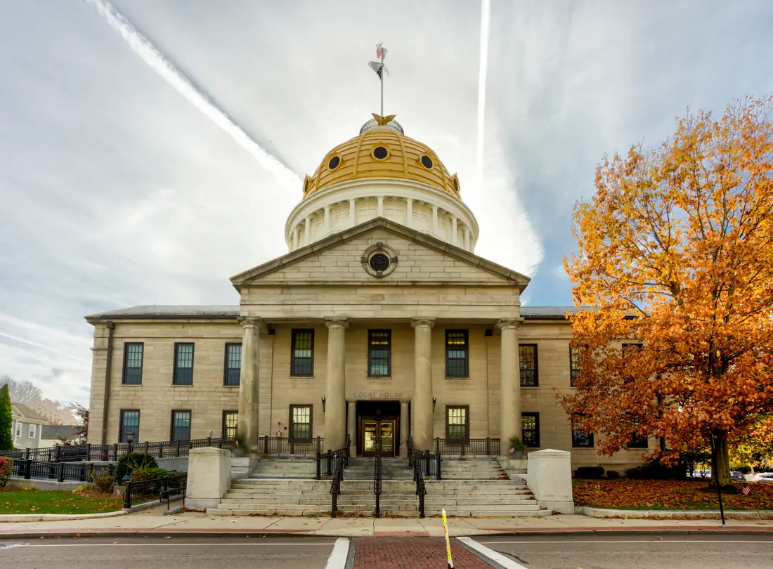 The granite facade and columned portico of the Norfolk County Courthouse in Dedham, Massachusetts.