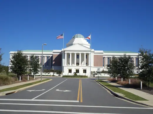The domed Florida First District Court of Appeal building in Tallahassee with flags flying out front.