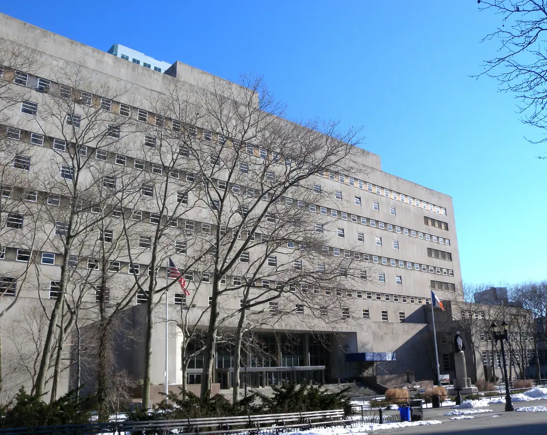 The Kings County Supreme Court building in Brooklyn seen from the street on a clear winter day, its columned facade in full sun.