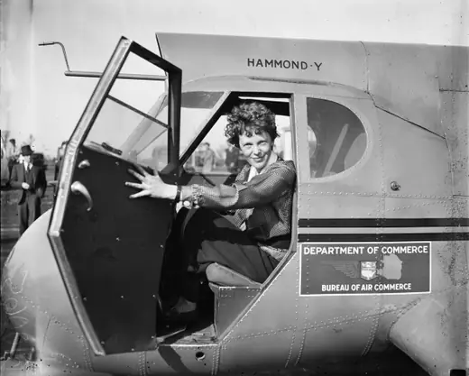 Amelia Earhart seated in the cockpit of a Stearman-Hammond Y-1 aircraft, looking toward the camera.
