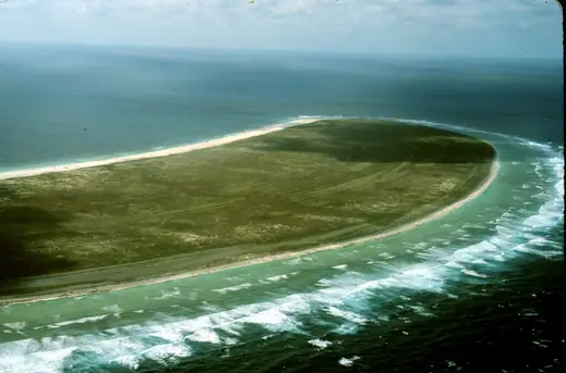 Aerial view of Howland Island, a low flat coral island surrounded by open ocean.