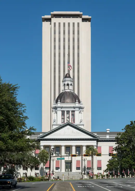 The historic domed Florida Capitol in front of the tall modern Capitol tower in Tallahassee, seen from the east.