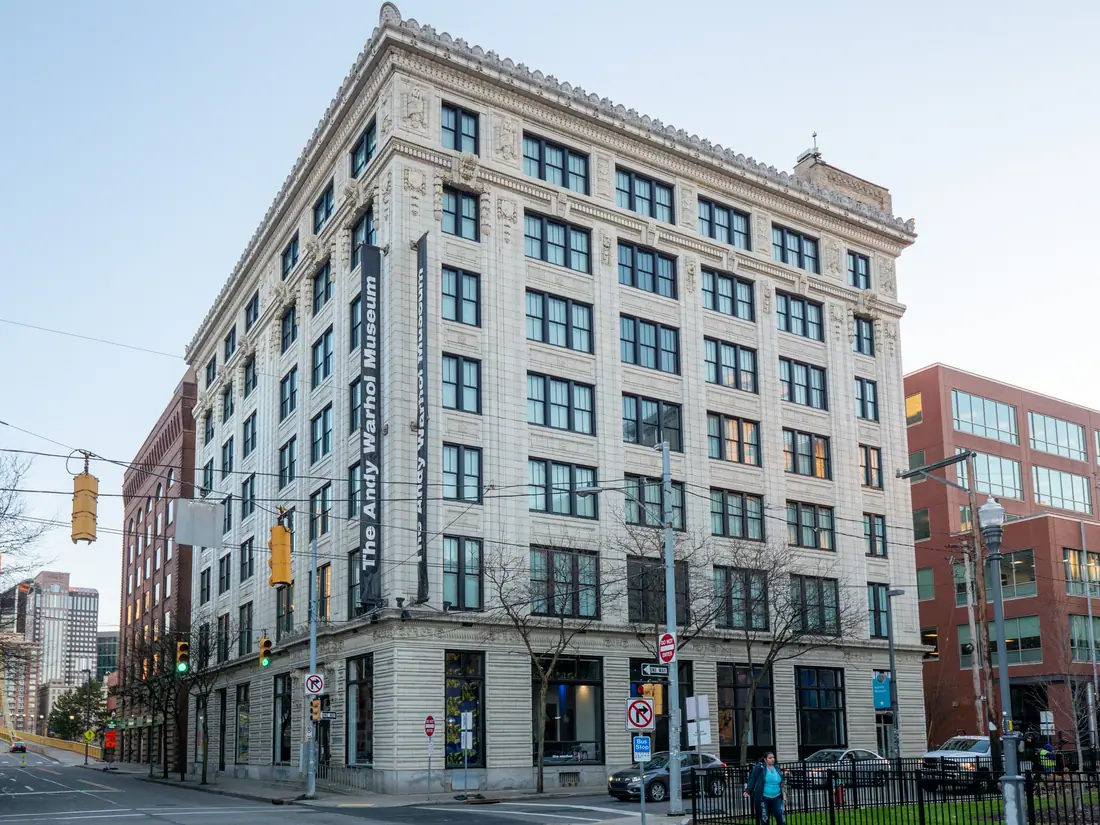 The brick facade of the Andy Warhol Museum in Pittsburgh, with the artist's name in tall letters down the corner of the building.