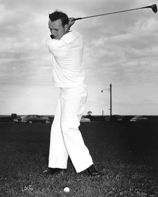 Young golfer in the 1950s mid-swing at an amateur championship.