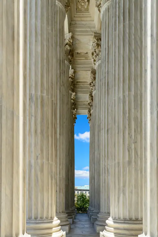 A vertical view up the marble columns of the United States Supreme Court building.