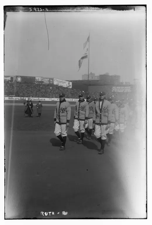 Baseball player in uniform photographed on the field at a stadium opening.