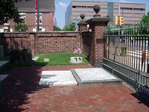 Flat stone grave marker of Benjamin and Deborah Franklin at Christ Church Burial Ground in Philadelphia, scattered with coins.