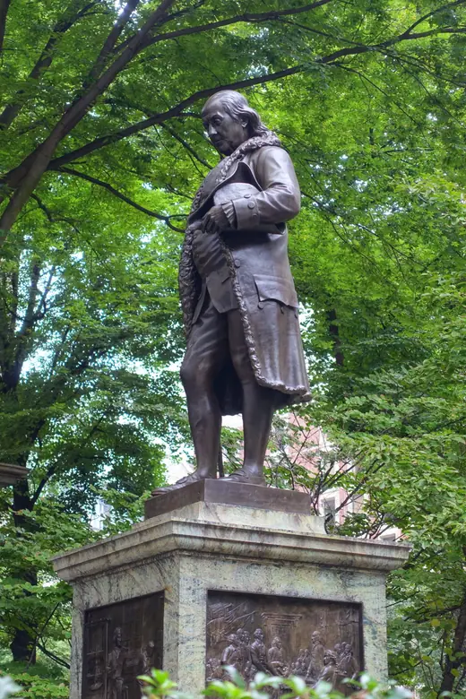 Bronze statue of Benjamin Franklin on a stone pedestal outside Old City Hall in Boston.
