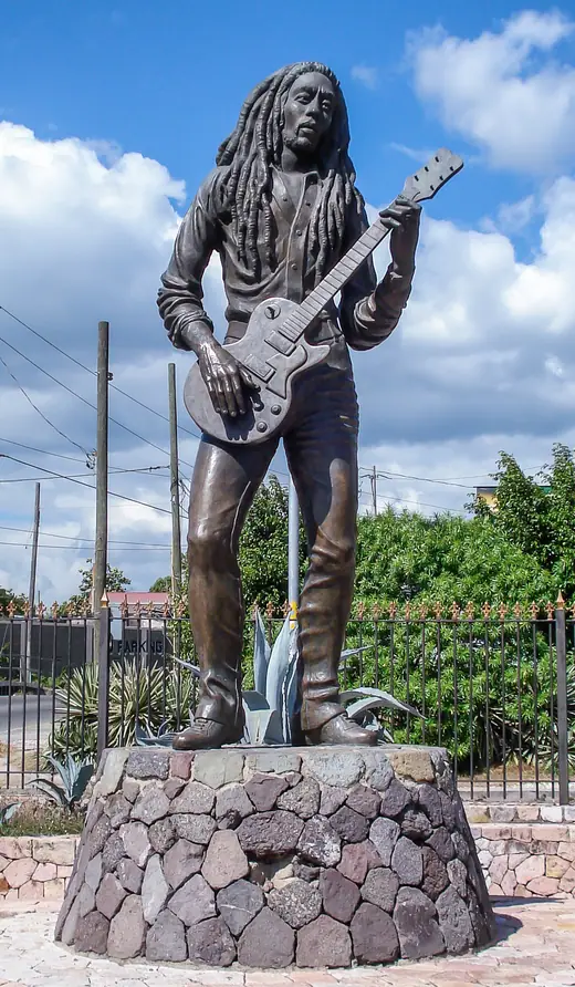 Bronze statue of Bob Marley holding a guitar, sculpted by Alvin Marriott, in Kingston, Jamaica.