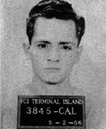 A small 1956 federal prison identification photograph of a young man in a plain shirt.