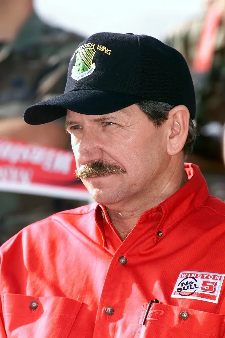 Dale Earnhardt in a flight-line jacket standing beside an F-15 Eagle during a weapons load crew competition at Langley Air Force Base.