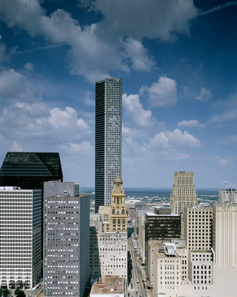 The downtown Houston skyline, a cluster of glass towers seen from street level.