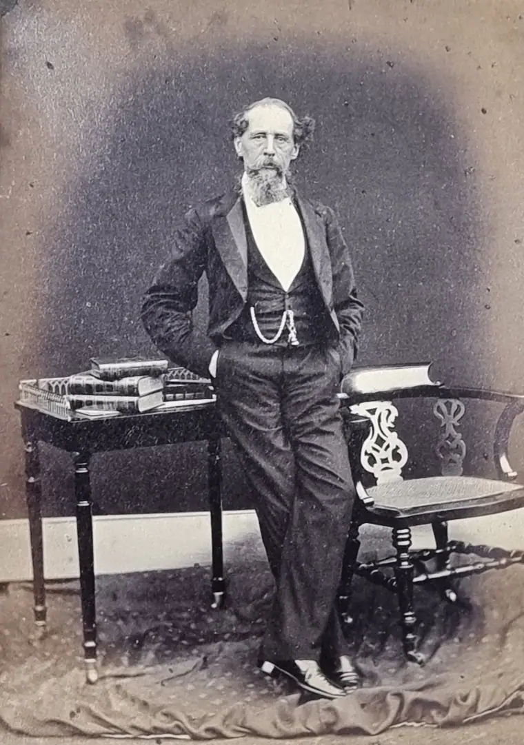Photographic portrait of Charles Dickens in middle age, seated, in a dark coat.