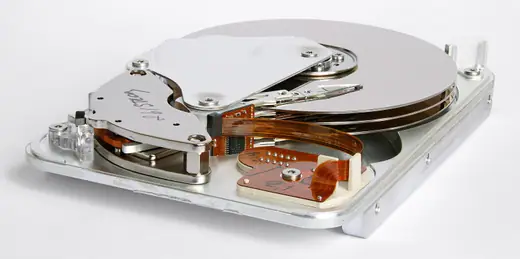 The interior of a 1998 Seagate hard disk drive showing platters, read-write heads and the actuator arm.