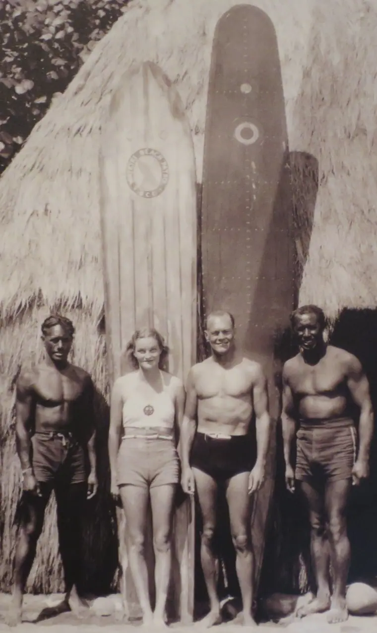 Doris Duke on the beach at Waikiki in the mid-1930s with three companions and a surfboard.