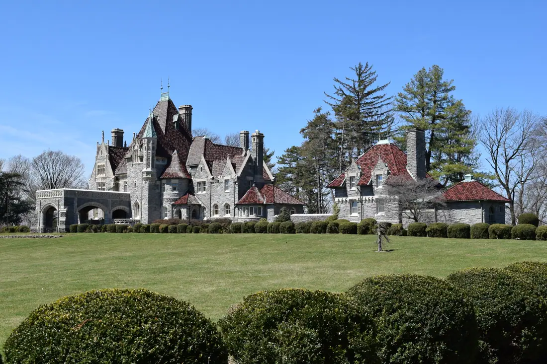 South facade of Woodmont, a French Gothic stone chateau in Gladwyne, Pennsylvania, seen from a curving drive.
