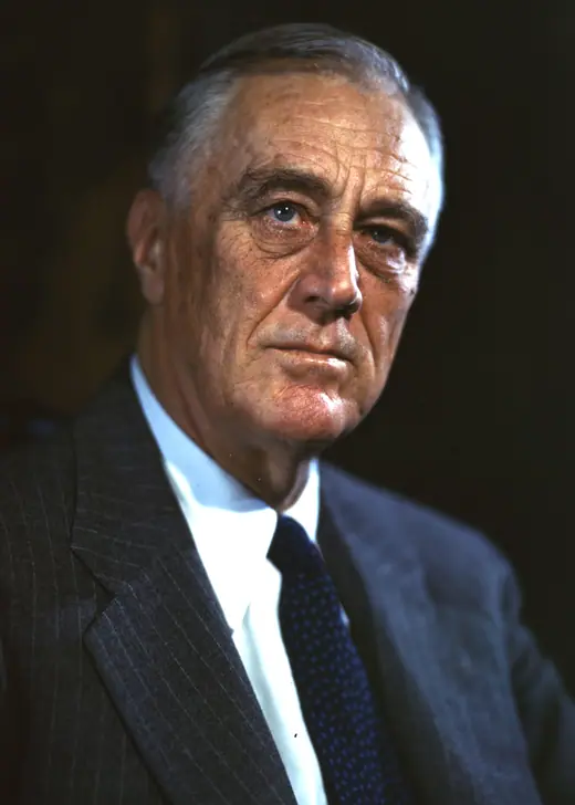 Colour transparency of Franklin D. Roosevelt seated in a dark suit and blue tie, looking to his right.