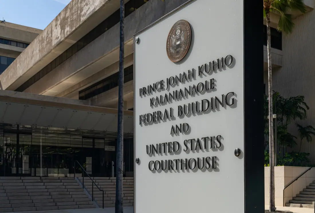 A tall concrete federal building and courthouse on a broad boulevard in downtown Honolulu.