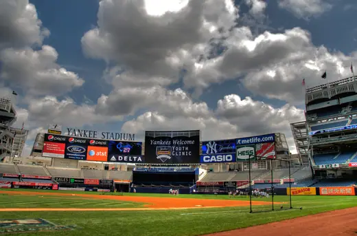 Interior of a modern baseball stadium with the field, infield dirt and packed tiers of seating.