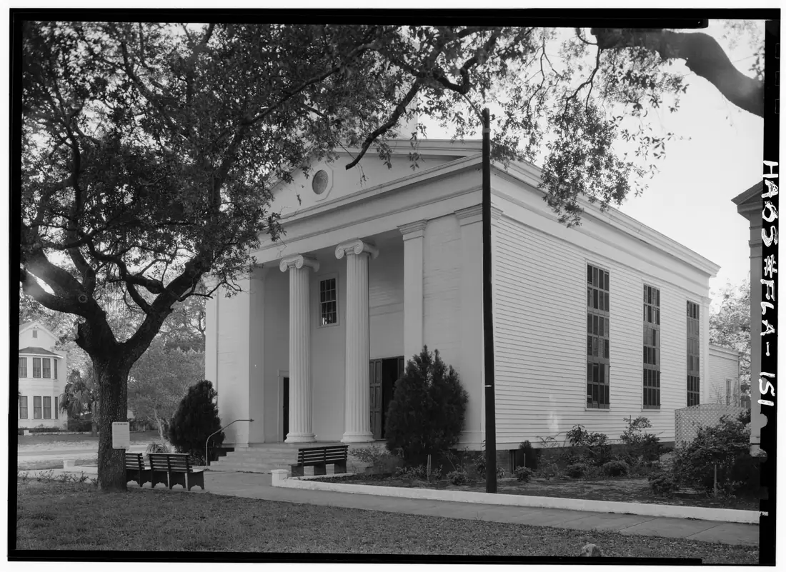 Front and northeast elevations of Trinity Episcopal Church, a white timber building on Gorrie Square in Apalachicola, Florida.