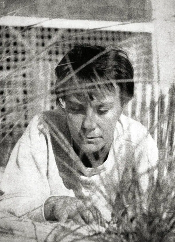 Black-and-white portrait of a young Harper Lee outdoors, short dark hair, looking past the camera.