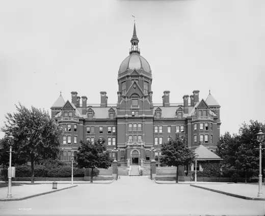 Wide photograph of the Johns Hopkins Hospital in Baltimore, its domed administration building rising above brick wings and bare trees.