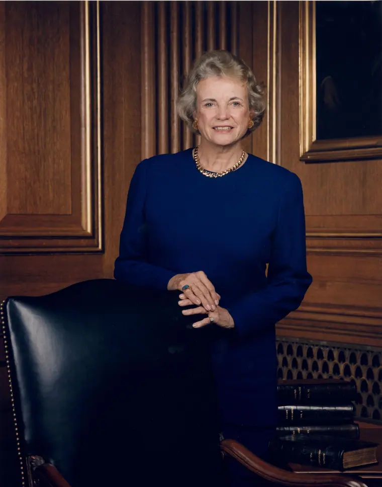 Official portrait of Justice Sandra Day O'Connor in judicial robes, seated and facing the viewer.