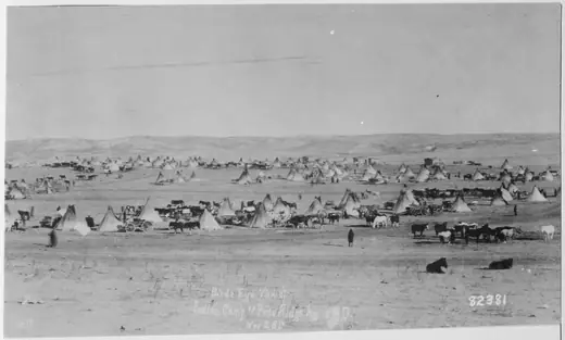 Elevated view of a large encampment of tipis spread across open ground at Pine Ridge, South Dakota, in 1890.