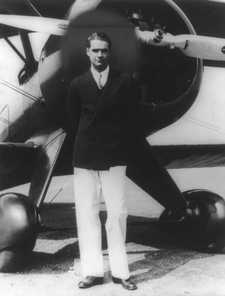Black-and-white portrait of a dark-haired man in a suit and tie with a thin moustache, looking slightly away from the camera.