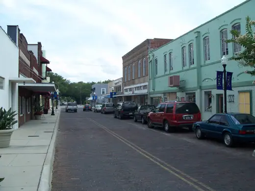 A street in the historic downtown district of Winter Garden, Florida, lined with low brick storefronts.