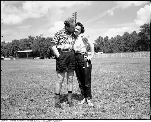 A couple in casual 1950s clothing at a spring training baseball camp.