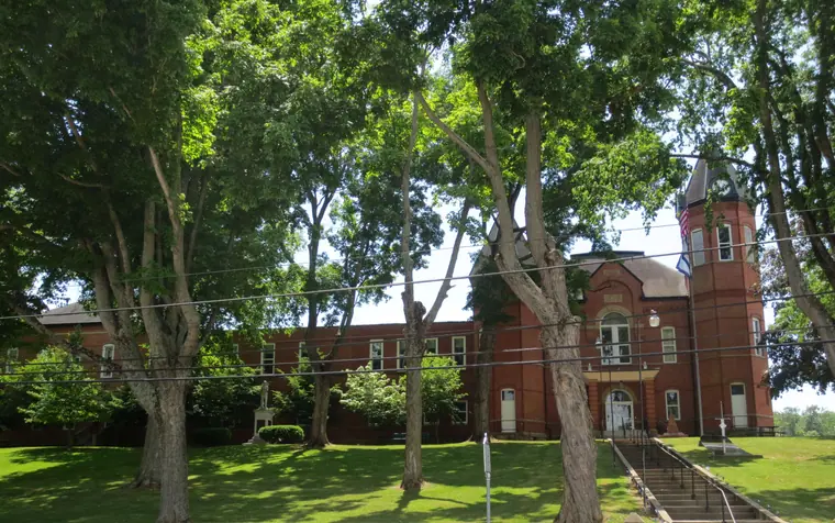 A 1900 Romanesque Revival stone courthouse with a modern brick annex attached at one side.