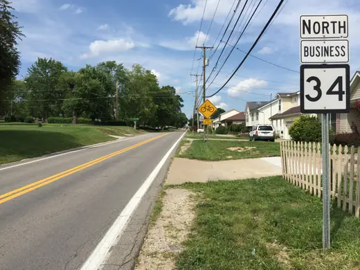 A two-lane small-town street lined with utility poles and modest commercial buildings.