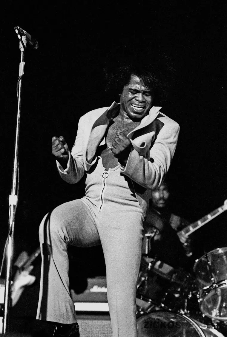 James Brown singing into a microphone on stage in Hamburg, Germany, February 1973.