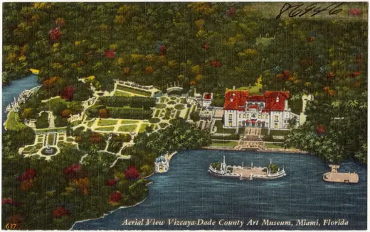 Colour postcard aerial view of a large villa and formal gardens beside a bay.