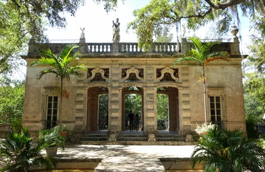 A small ornate garden pavilion with an arched loggia at the head of a formal parterre.