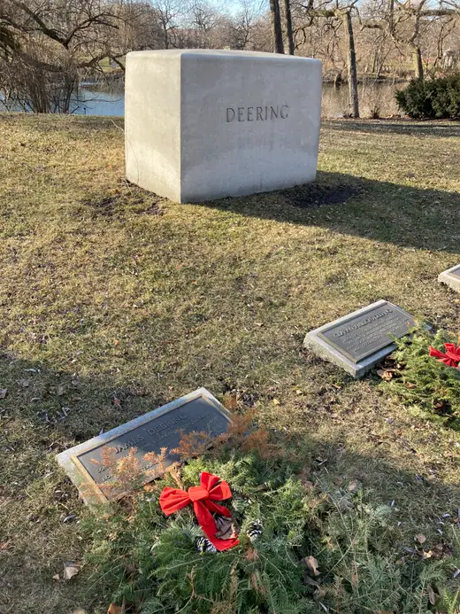 A plain granite grave marker set in grass, carved with a name and dates.