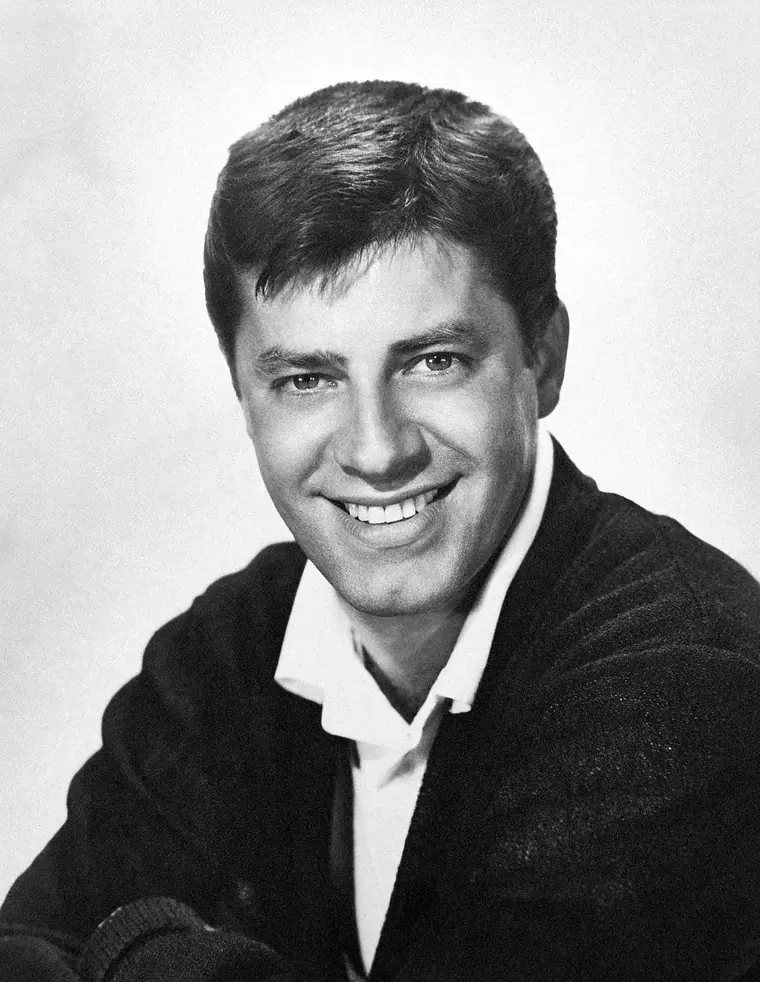Studio portrait of a young comedian in a jacket and tie, 1957.