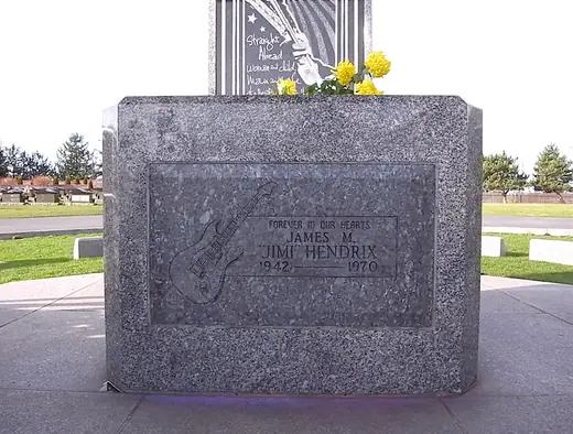 Granite headstone bearing a carved guitar and Jimi Hendrix's name at Greenwood Memorial Park in Renton, Washington.
