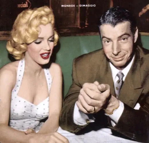 A magazine cover photograph of a smiling couple, the woman in a fur collar and the man in a dark overcoat.