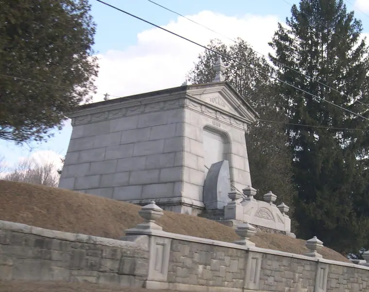The Laurel Glen Mausoleum in Cuttingsville, Vermont, with the marble statue of John Bowman kneeling on the entrance steps.