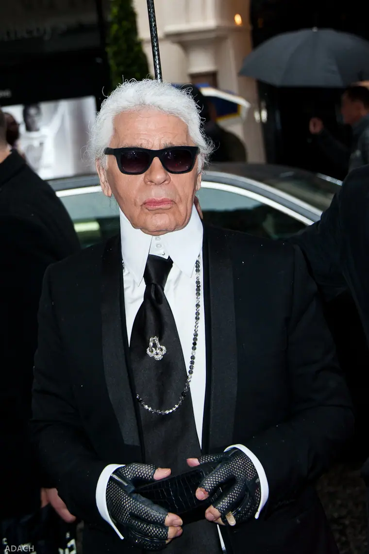 Karl Lagerfeld in dark glasses and a high white collar at a Fendi store opening in 2014.