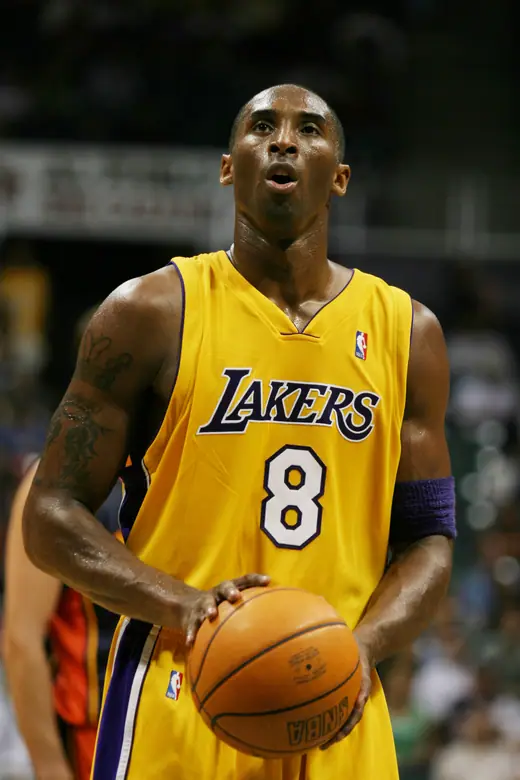 Basketball player at the free-throw line, ball raised, preparing to shoot.