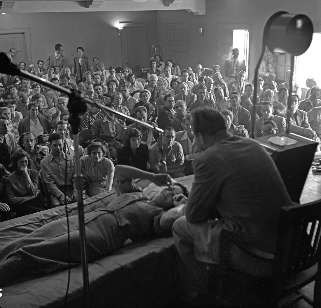 Black-and-white press photograph of a 1950 seminar in Los Angeles, with a speaker addressing a seated audience.