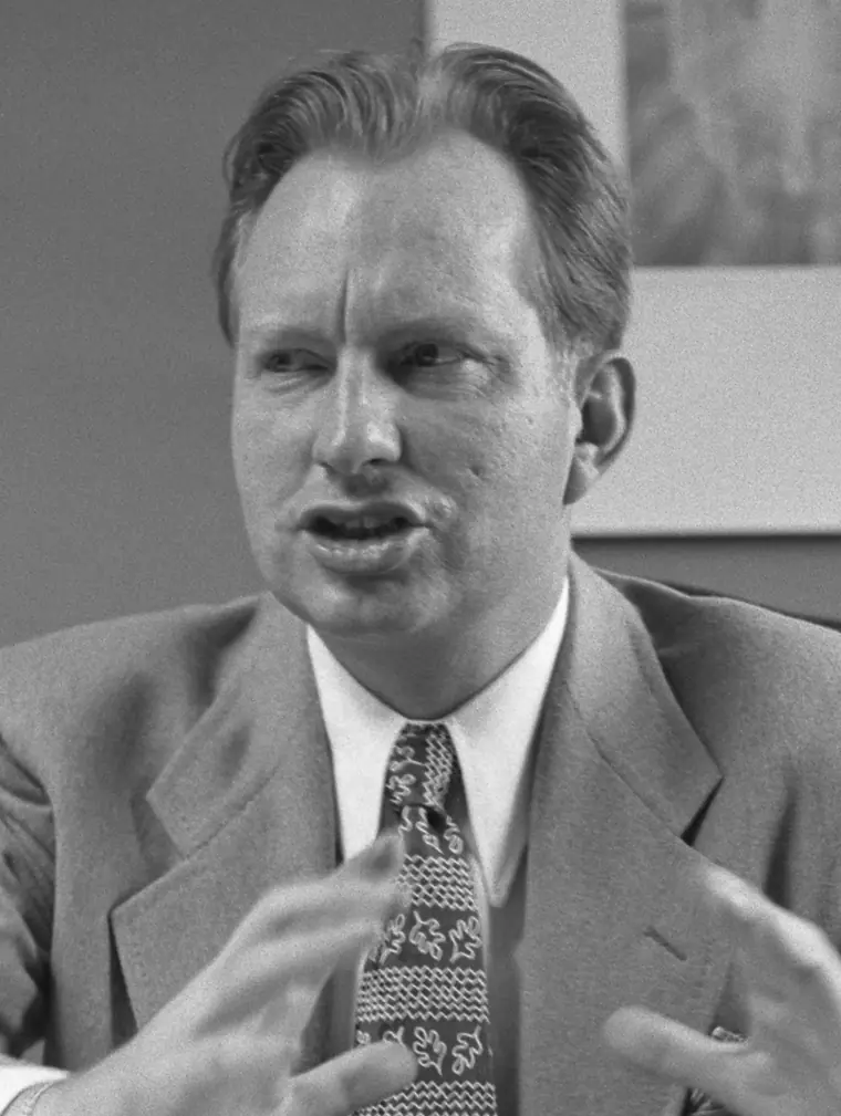 Portrait photograph of L. Ron Hubbard in a suit and tie, seated, looking toward the camera.