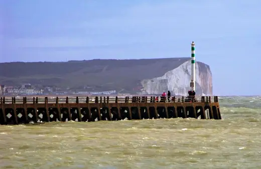The eastern breakwater at Newhaven Harbour running out into grey water under an overcast sky.