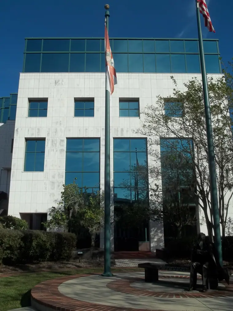 A modern multi-storey county courthouse in Tallahassee photographed from below against a clear sky.