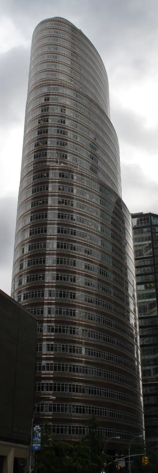 Narrow vertical view of the elliptical Lipstick Building rising above Third Avenue.