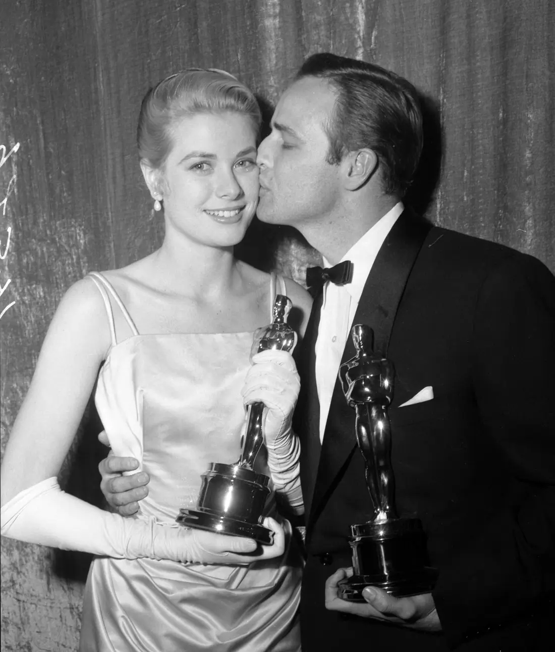 Marlon Brando and Grace Kelly holding their Oscars at the 27th Academy Awards at the Pantages Theatre in Los Angeles.